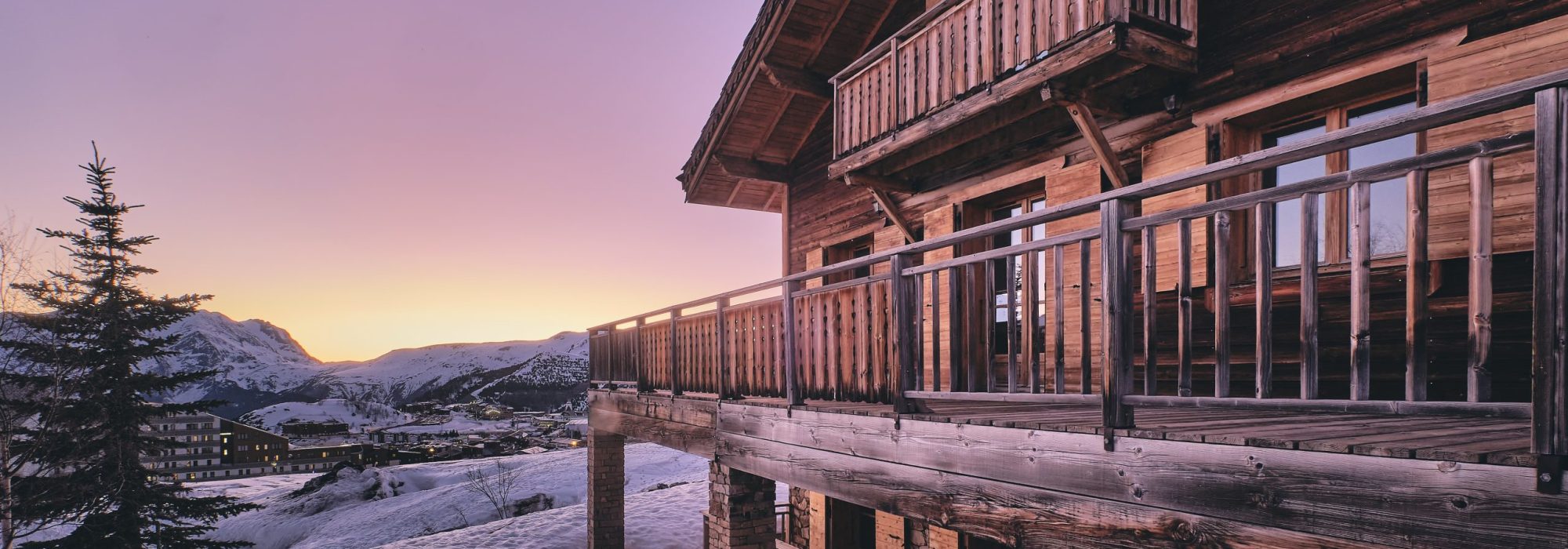 Long shot of the facade of a cabin in Alpe d Huez ski resort in the French Alps during sunrise A long shot of the facade of a cabin in Alpe d Huez ski resort in the French Alps during sunrise